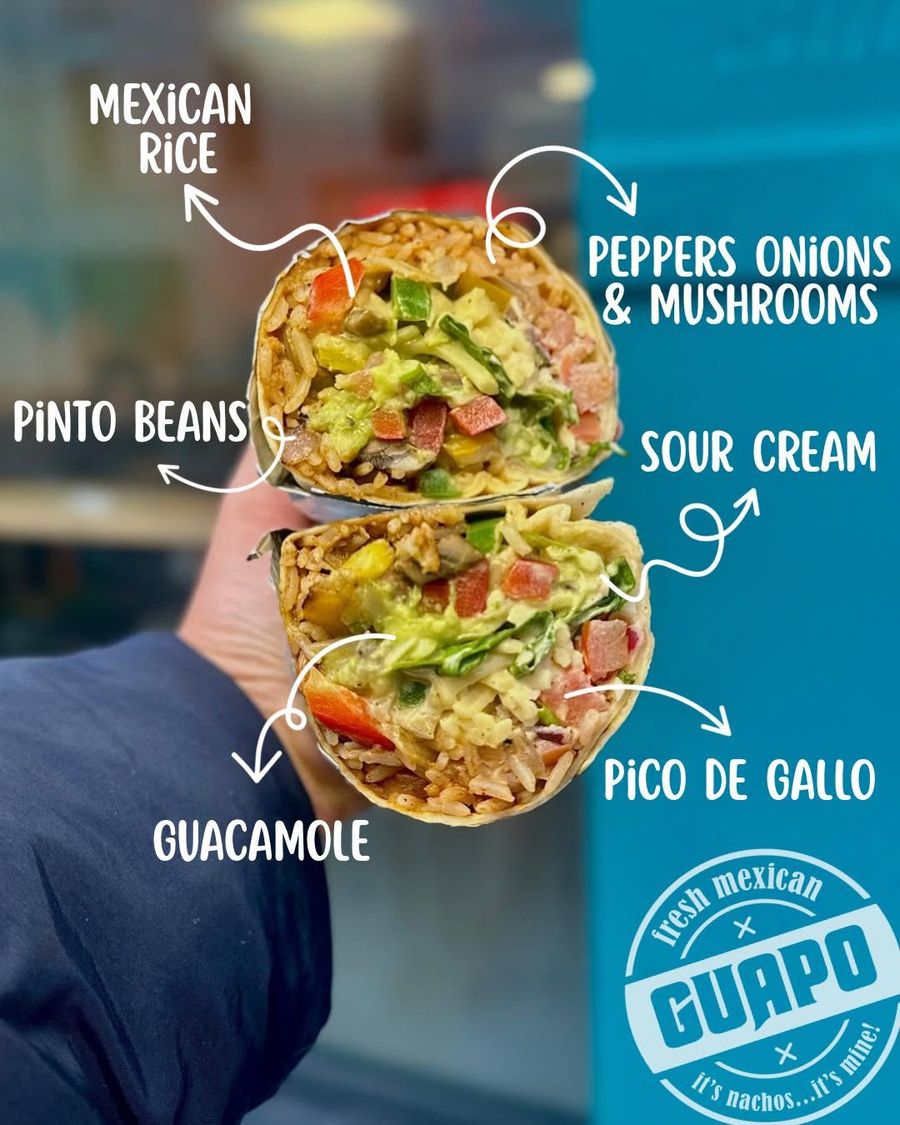 A Guapo burrito cross-section labelled with Mexican rice, pinto beans, guacamole, peppers, mushrooms, sour cream, and pico de gallo
